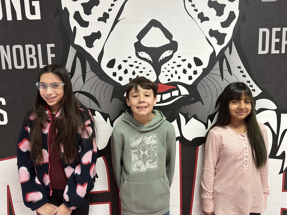 3 6th grade students in front of the jaguar mural 