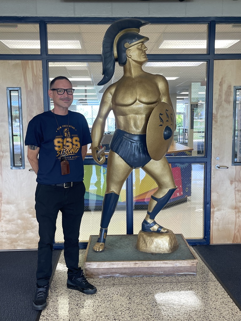 SSS AP Philip Trent Hall standing next to Spartan statue
