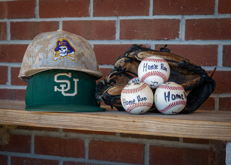 Baseballs, hats and a baseball glove