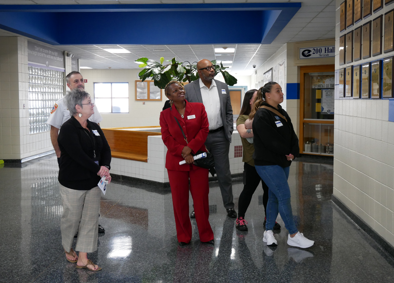 Mrs. Wendy Mozingo shows visitors the display of plaques that show the names of all students that receive the Academic Achievement Award each year for having a cumulative average of 94.5.