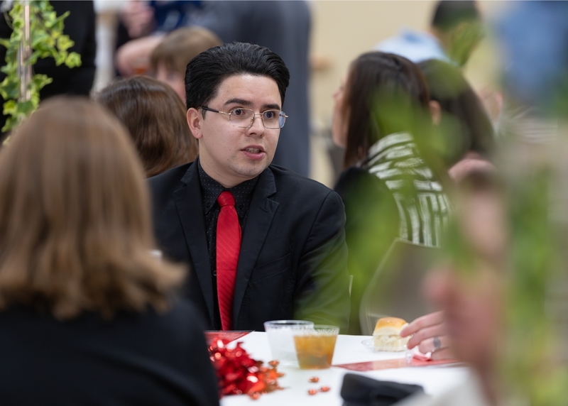 Andrés Mena, an English as a Second Language (ESL) teacher at Smithfield Middle, mingles with colleagues while enjoying light fare before the ceremony begins.