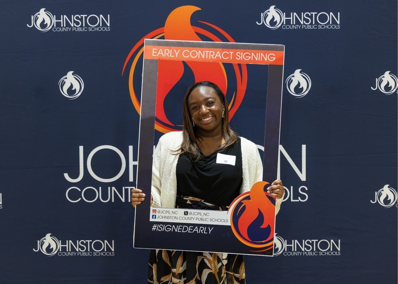 A job fair attendee signs an early contract for the 2026-2027 school year.