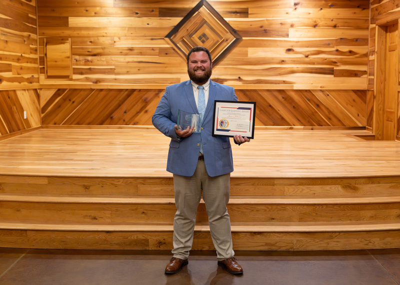 Flame for Learning winner James Johnson stands with his trophy and certificate.