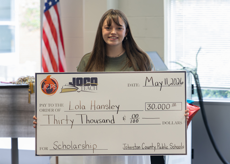 Lola Hansley holds her scholarship check