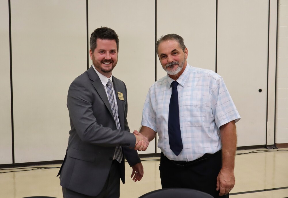 school board members Matthew Pritz and Andrew Smith shaking hands