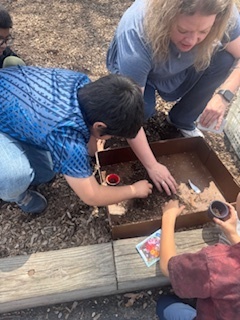 Students planting seeds on clay pots