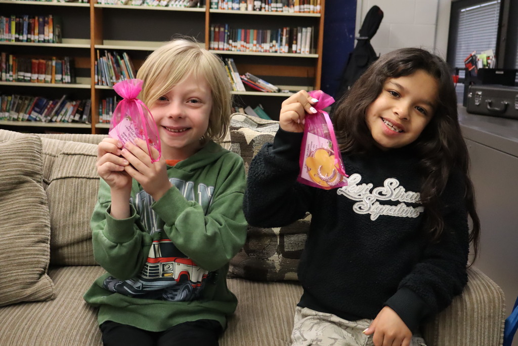 Two students showing their Mother's Day gifts