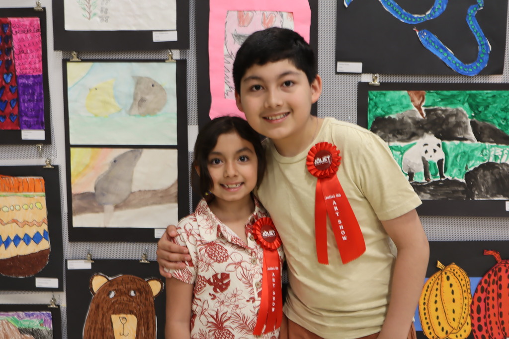 Two students with ribbons at the art show