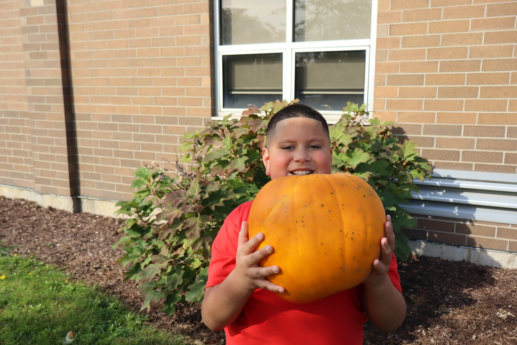 Thigpen student pick up a pumpkin
