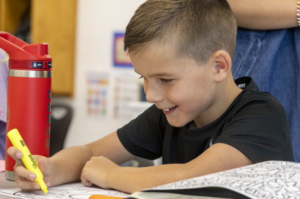 student drawing and smiling