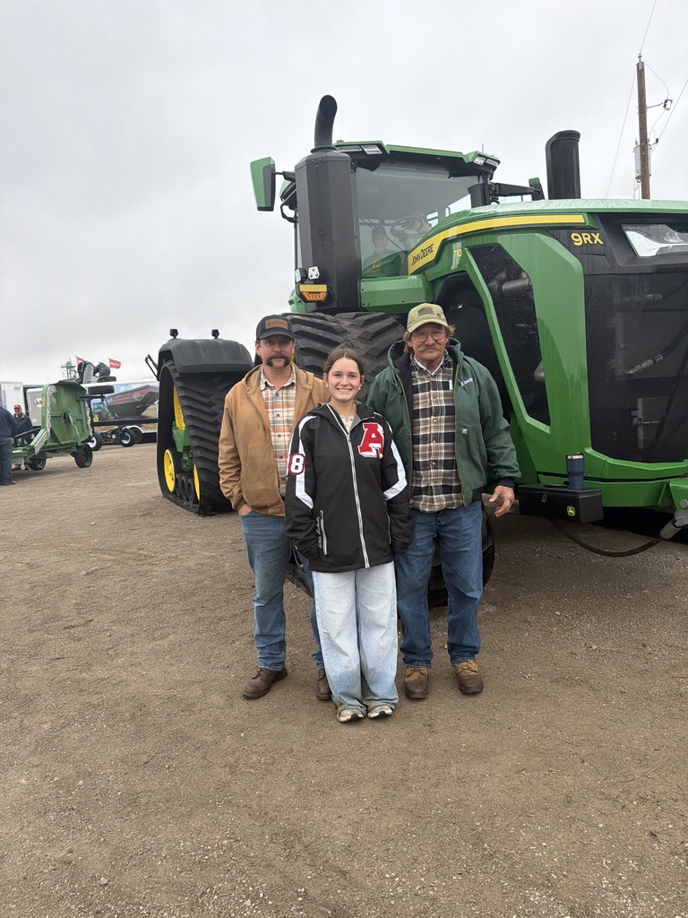 student posing with tractor
