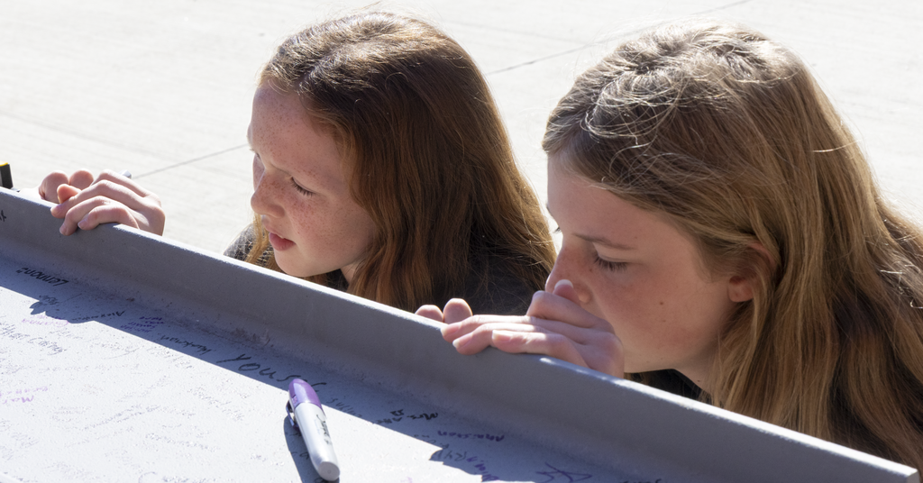 students at beam signing