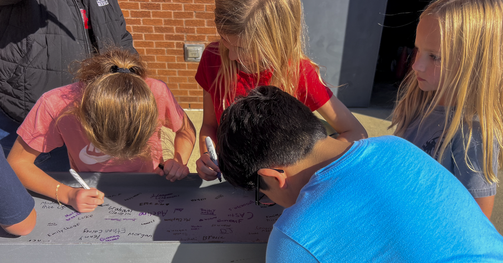 students at beam signing