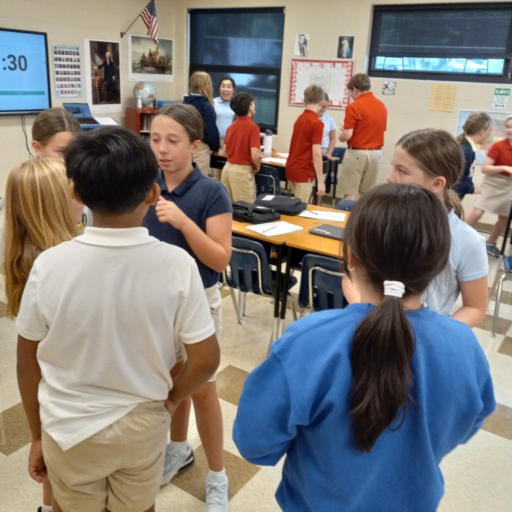 students standing working throughout a classroom