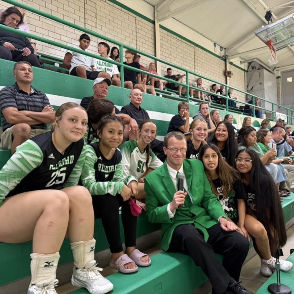 group photo of h.s students in a gym with their former j.h. teacher