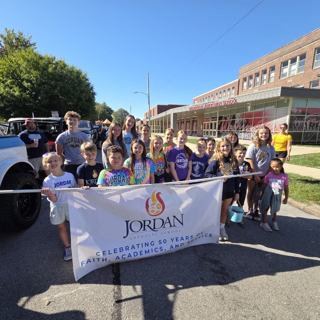 group photo of students holding a Jordan banner for the parade