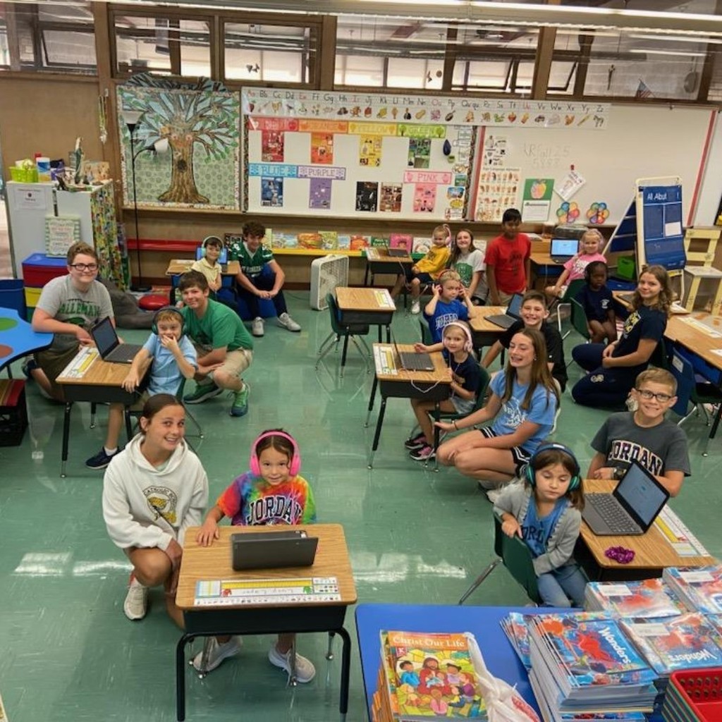 7th grade students helping kindergartners take tests on their Chromebooks