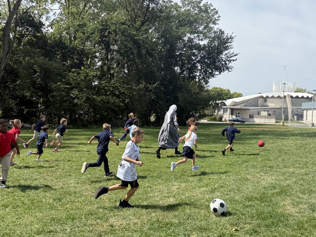 students and Sr. Mary Solanus playing soccer at recess