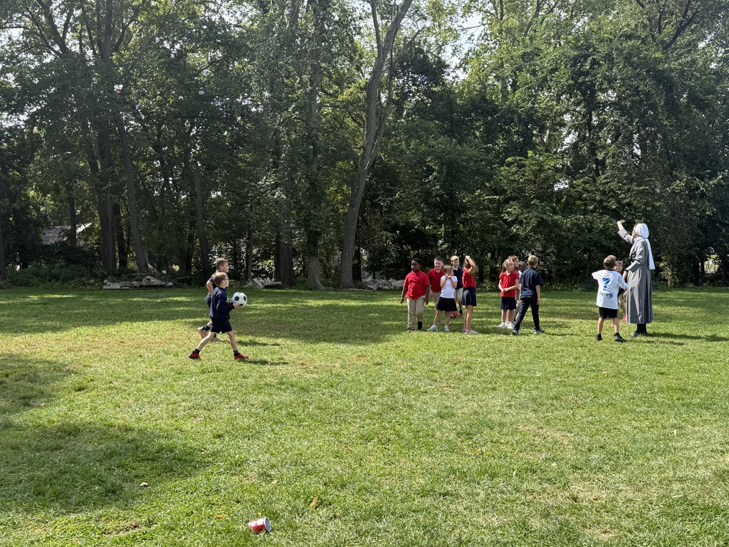 students and Sr. Mary Solanus playing soccer at recess
