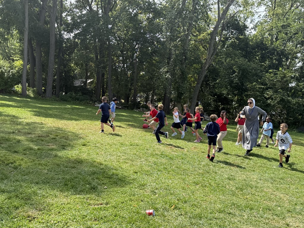 students and Sr. Mary Solanus playing soccer at recess