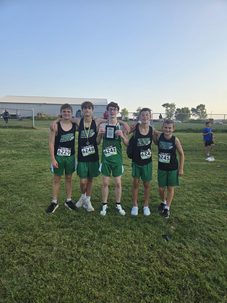 photo of 5 cross country runners at a meet holding a plaque