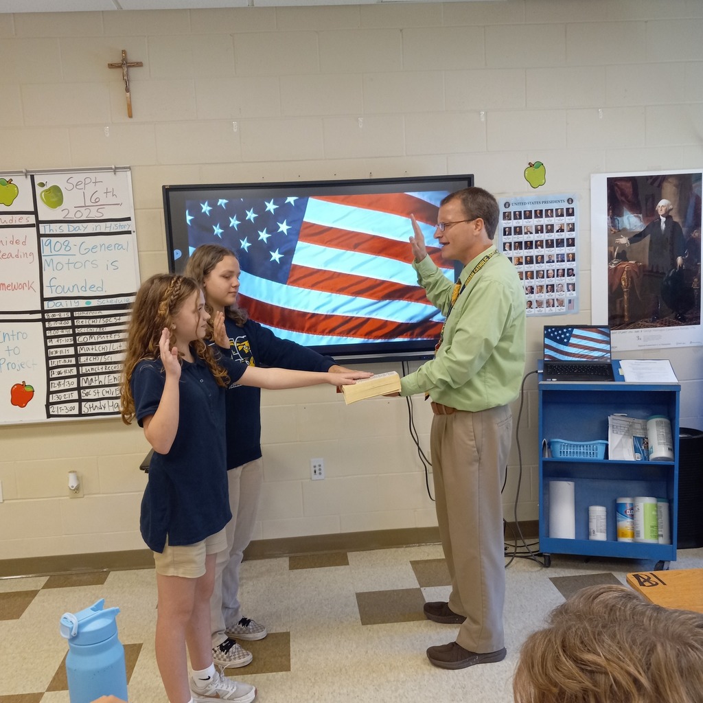 two students being sworn in with their hands on a bible