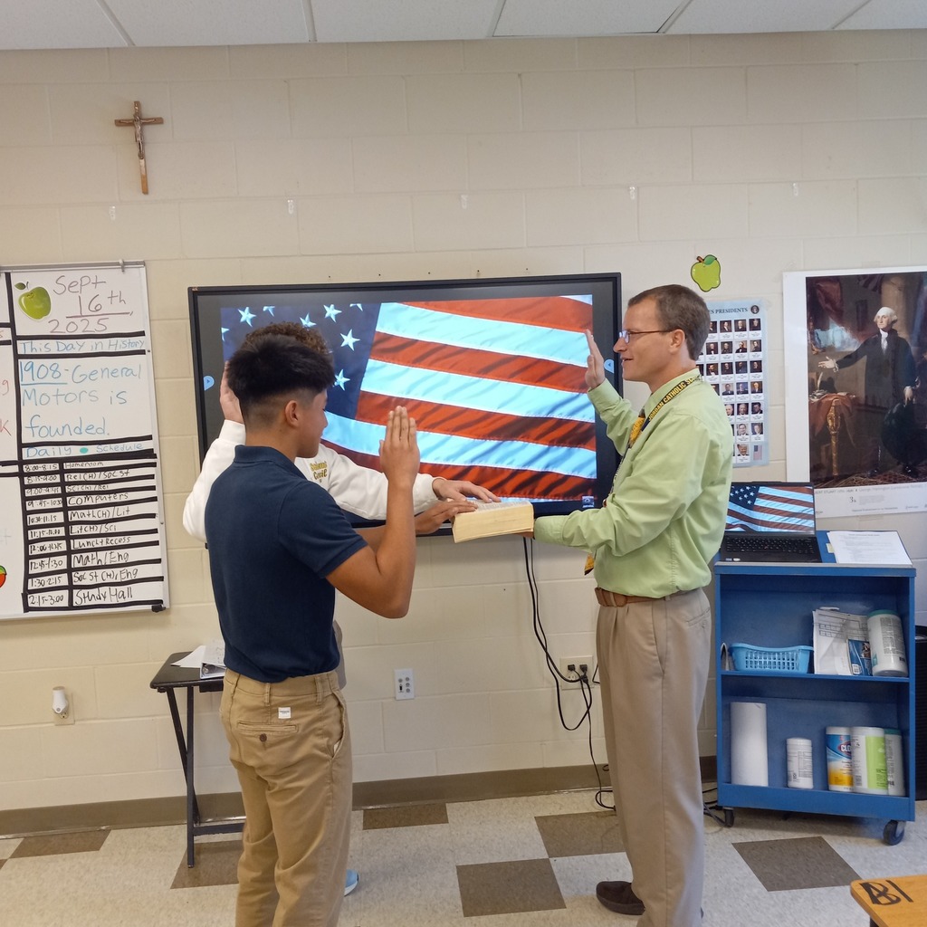 two students being sworn in with their hands on a bible