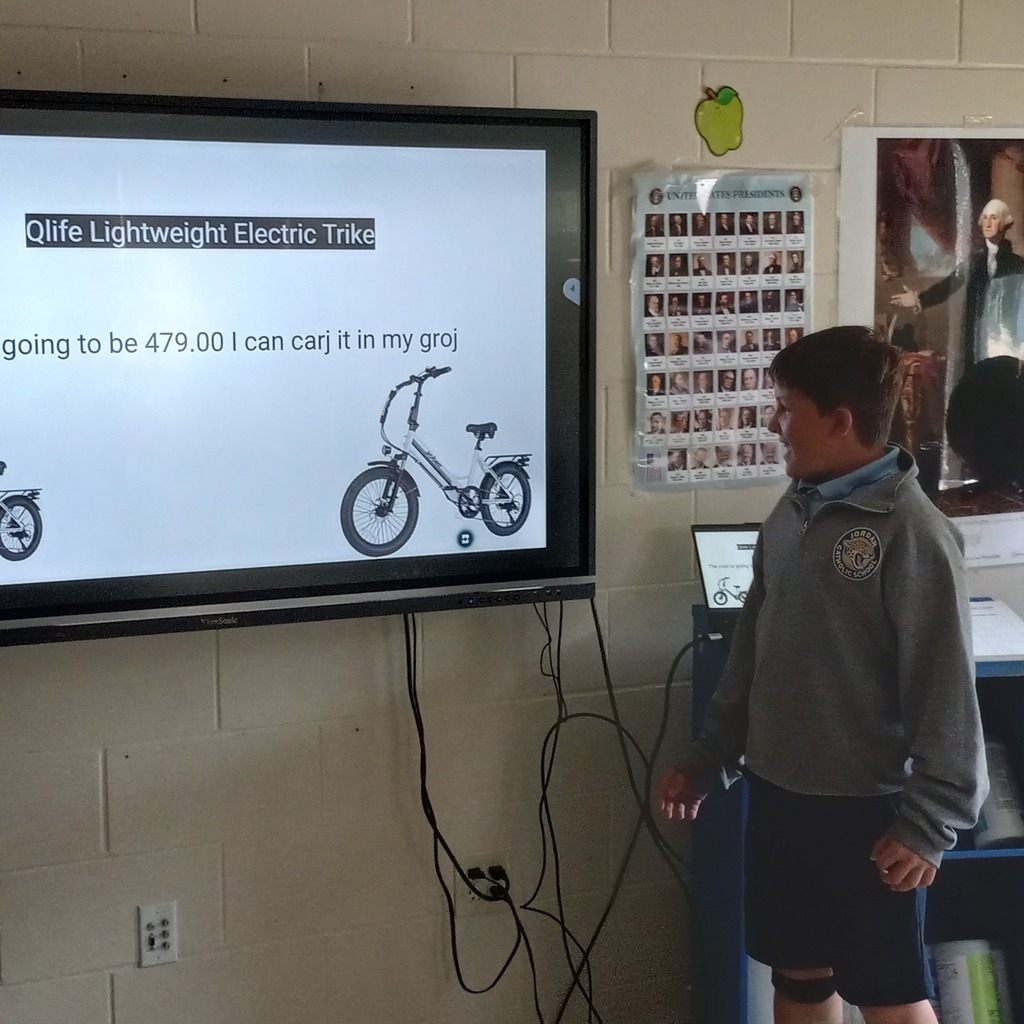 student presenting information on a digital panel in a classroom