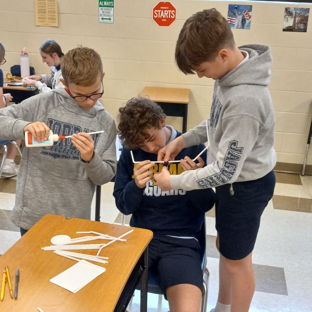 students using plastic straws and tape to build a ceremonial tower