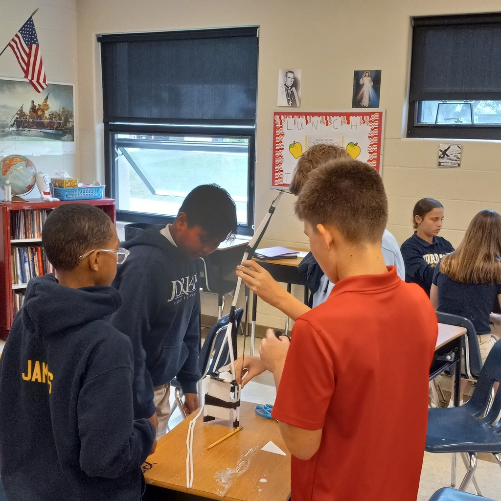 students using plastic straws and tape to build a ceremonial tower