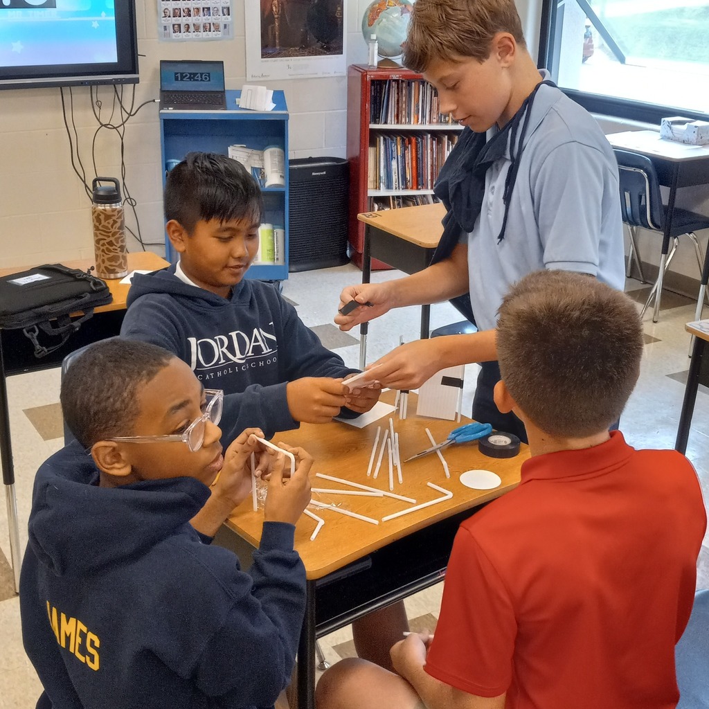 students using plastic straws and tape to build a ceremonial tower