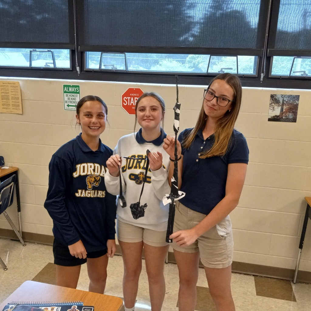 students posing in a classroom with their ceremonial tower made from straws and tape