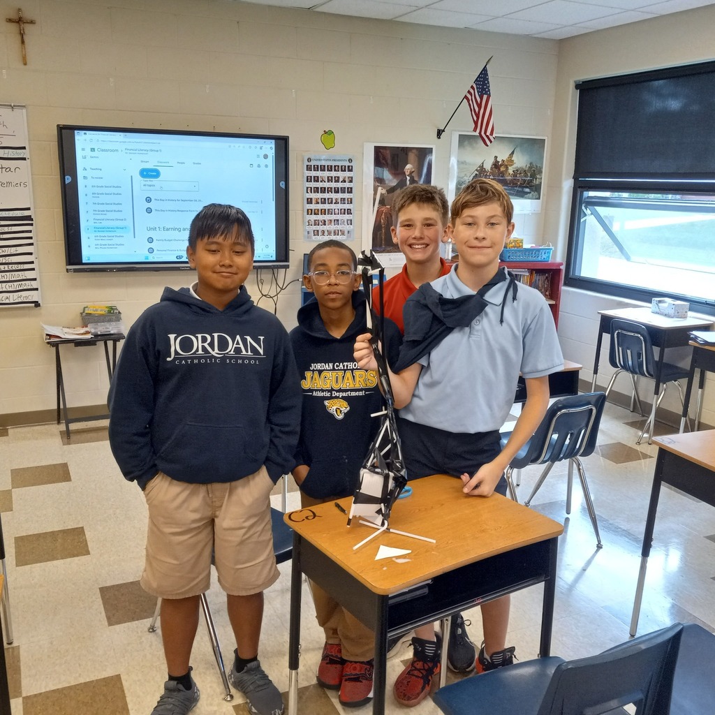 students posing in a classroom with their ceremonial tower made from straws and tape