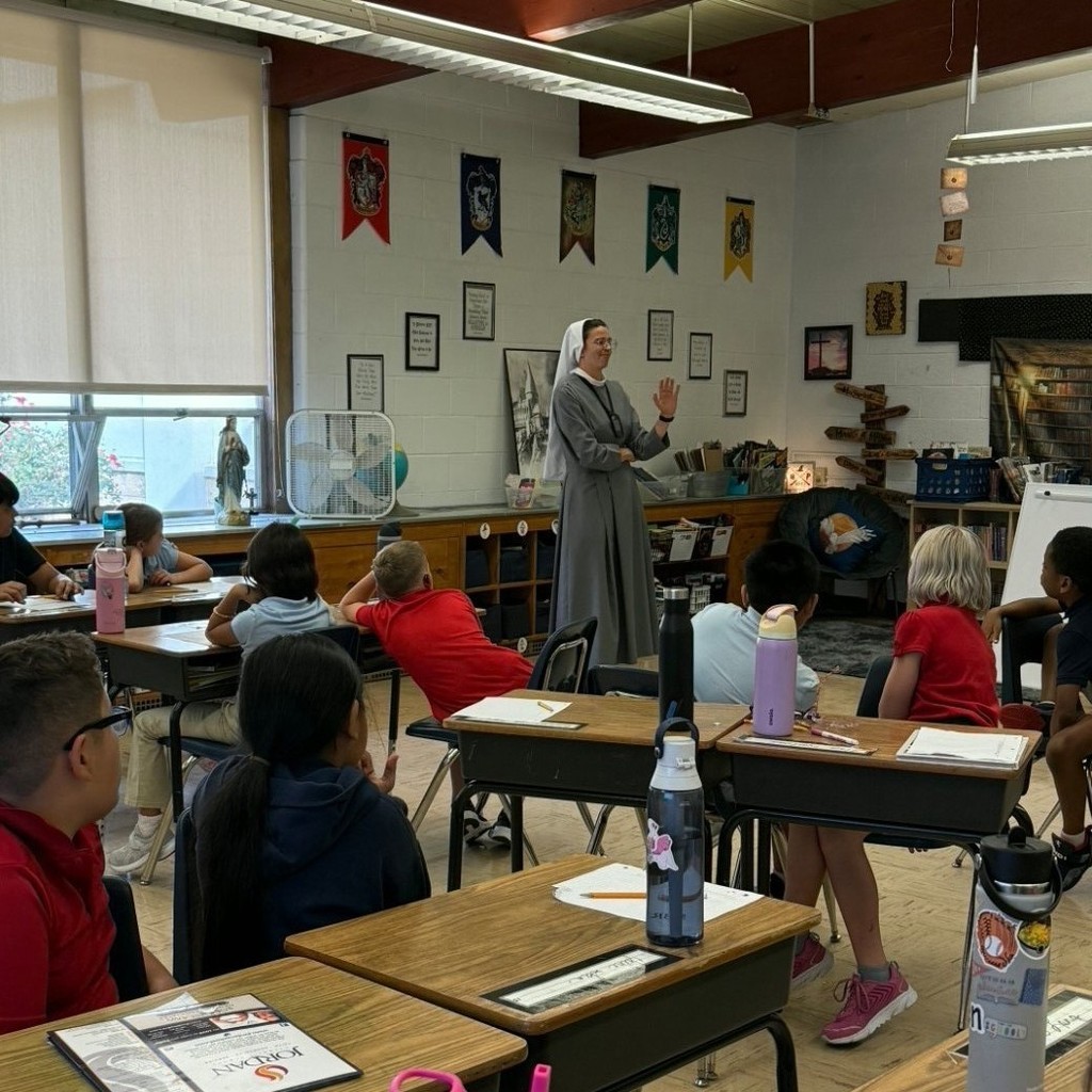Sr Mary Solanus speaking to a class of students sitting at desks