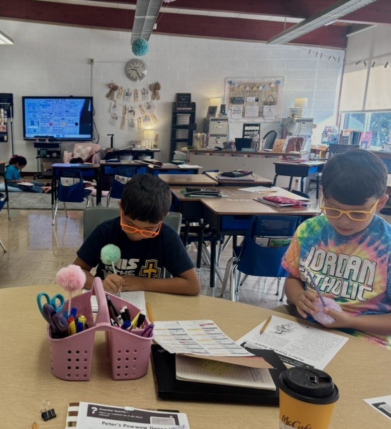 students sitting at a table working on a worksheet together