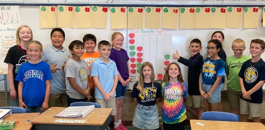 4th grade students posing in front of their favorite apples bar graph
