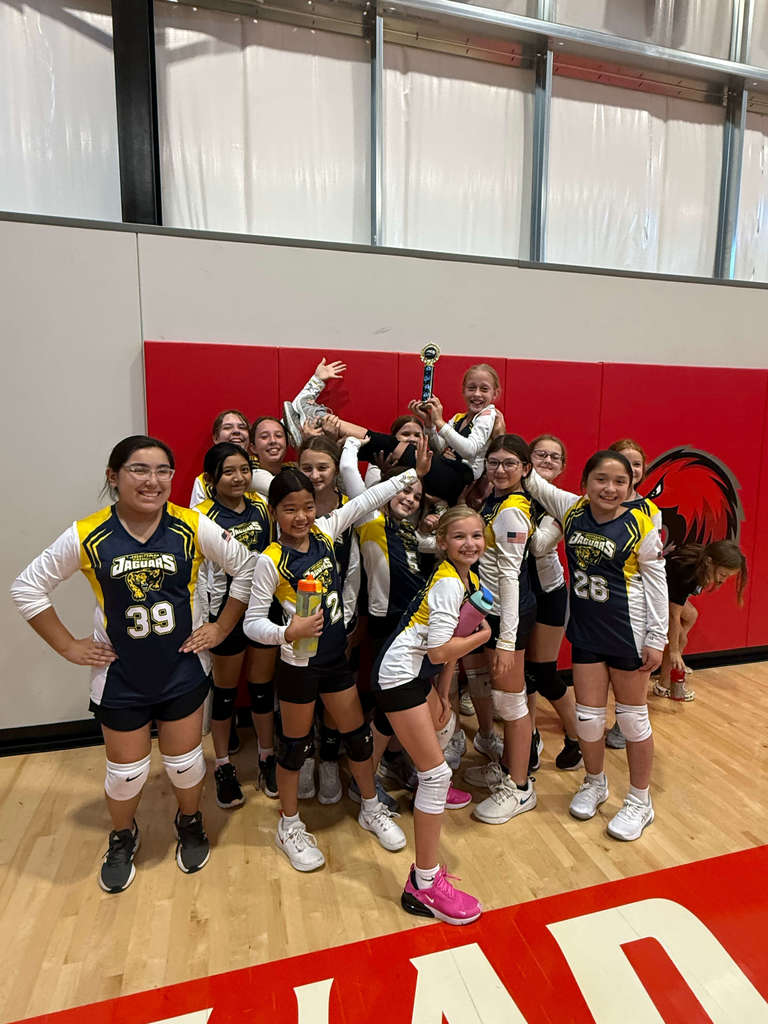 team photo of 6th grade Volleyball holding player and 3d place trophy in the air