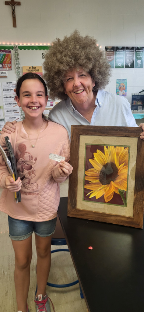 student posing with art teacher who is dressed as Bob Ross