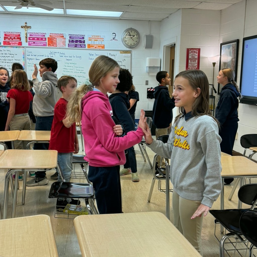 students standing in pairs in a classroom