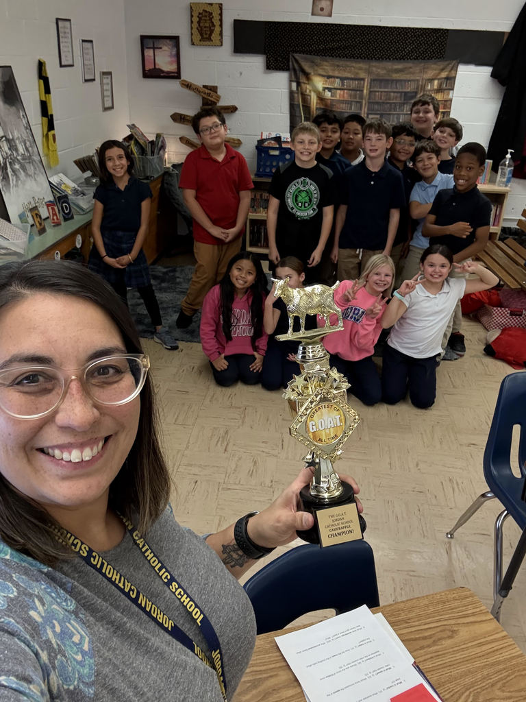 students and teacher posing with GOAT trophy
