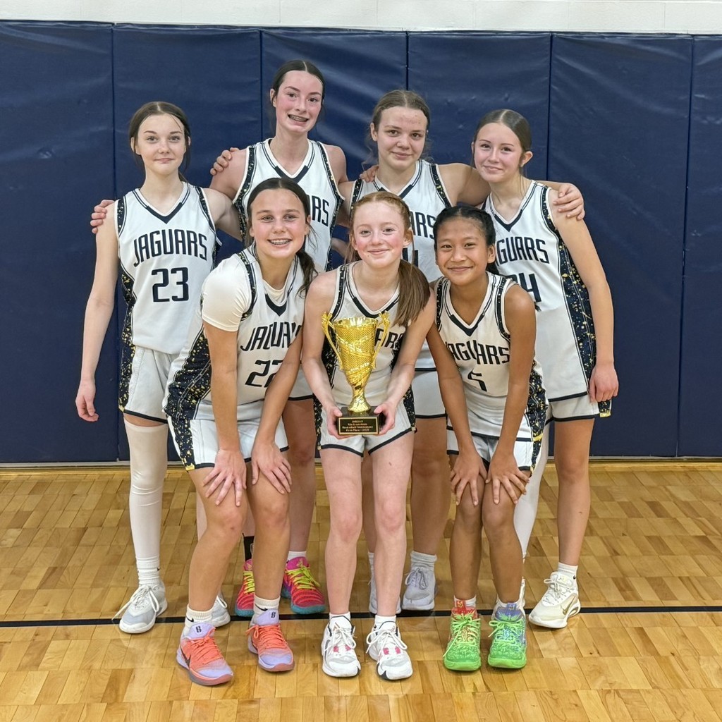 girls basketball team posing with trophy