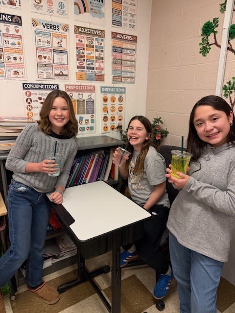 three students posing with sodas