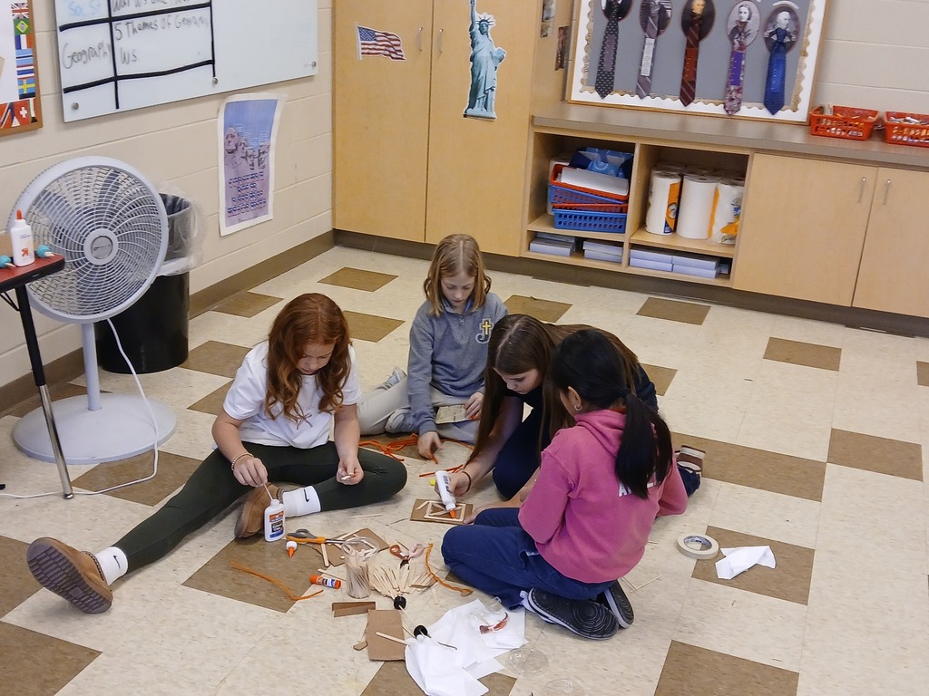 students using cardboard and tape to build a car