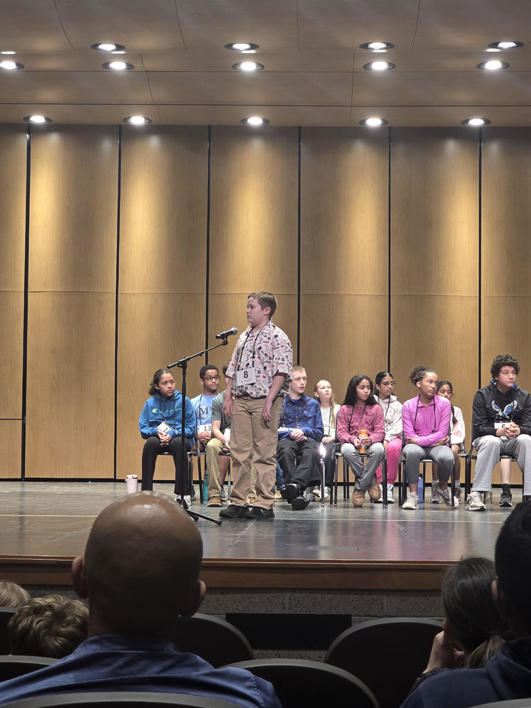 student speaking into a microphone on a stage
