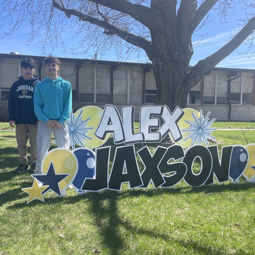 students posing with yard signs