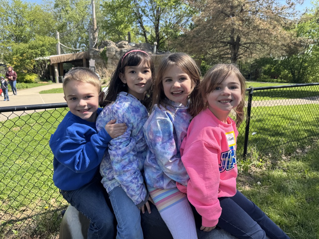 kids smiling in front of a fence