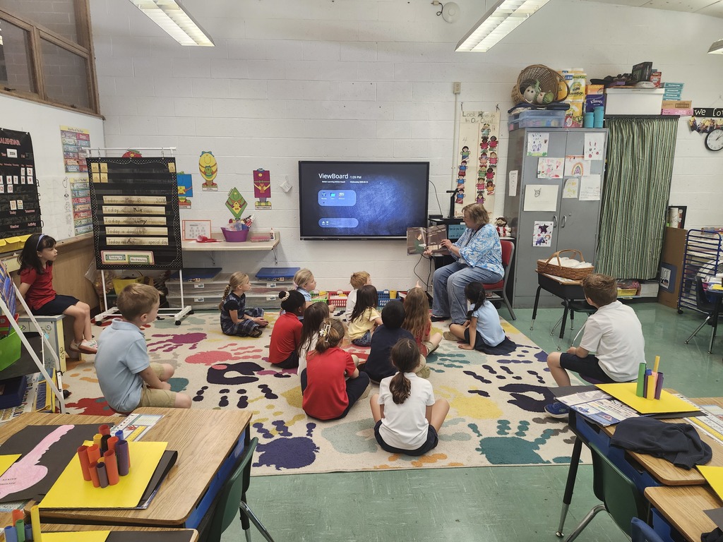 students listening to teacher reading a book