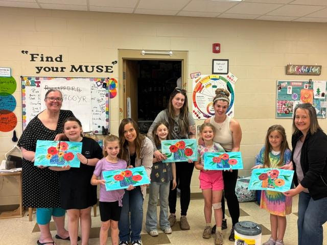 moms and daughters posing with paintings
