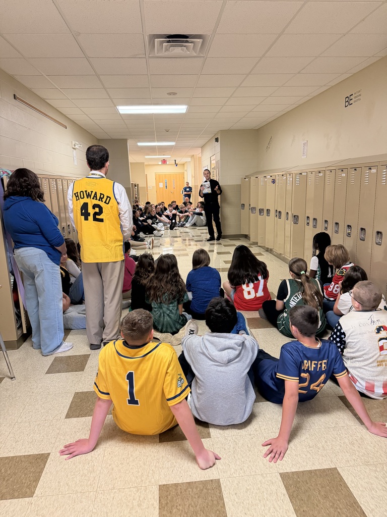 students sitting in the hall listening to a speaker