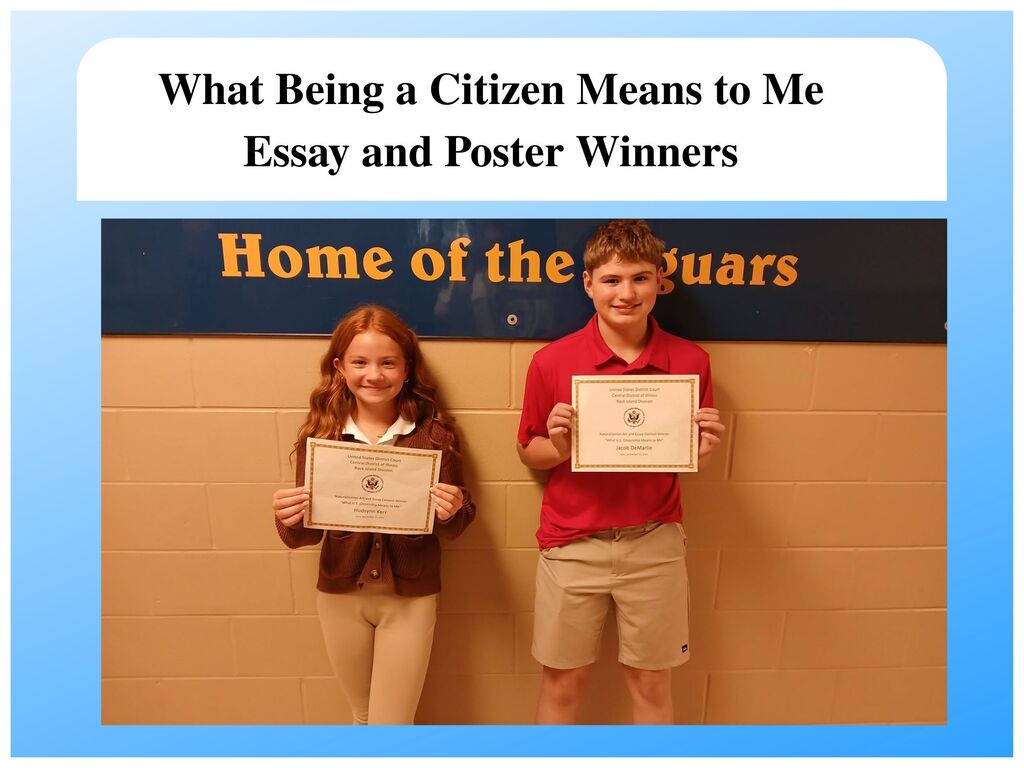 A promotional graphic featuring two students holding award certificates under a top banner reading "What Being a Citizen Means to Me Essay and Poster Winners".   Header: A white rounded banner at the top displaying bold black text.   Left Student: A smiling girl with reddish hair wearing a brown cardigan sweater and beige pants holding a certificate from the United States District Court Central District of Illinois.   Right Student: A smiling boy in a red polo shirt and tan shorts holding a matching certificate.   Background: The students stand against a brick wall beneath a dark blue wall sign with yellow lettering that reads "Home of the Jaguars". 